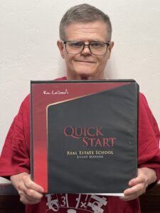 Me holding Ron's Quick Start Real Estate School Manual
